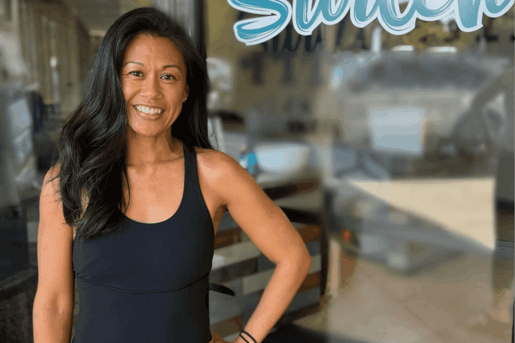 Smiling woman standing in front of store.